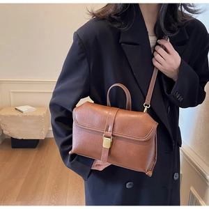 Brown vintage faux leather crossbody bag styled with a professional black blazer