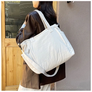 Detail der weißen gesteppten Nylon-Tote-Bag mit Reißverschluss und verstellbarem Gurt