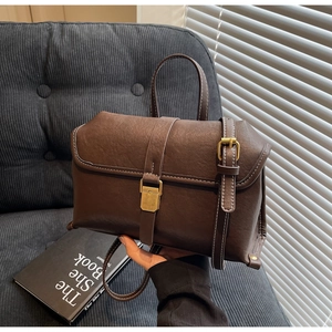 Detailed view of the dark brown retro leather bag showing white stitching and gold metal buckle