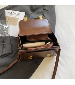 Macro view showing internal space of brown faux leather bag with wallet and phone
