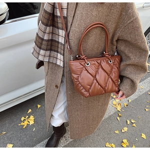 Gros plan du sac seau matelassé marron en cuir souple avec un style automnal