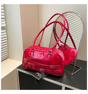 Détail du sac à main rouge brillant avec nœud et boucles décoratives élégantes