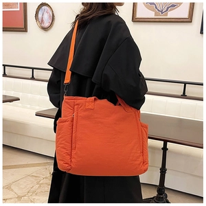 Helle orangefarbene gesteppte Nylon-Tragetasche mit Schultergurt und großen Seitentaschen