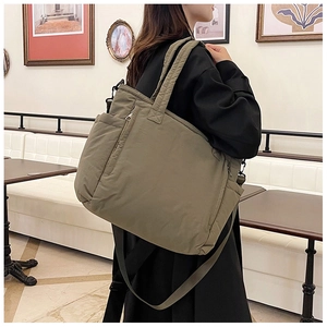 Detail der olivgrünen gesteppten Nylon-Tasche mit Seitentaschen und Gurtband