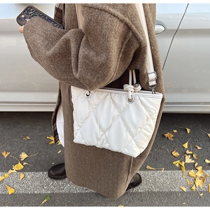 Détail du sac seau matelassé blanc en cuir souple avec œillets métalliques argentés