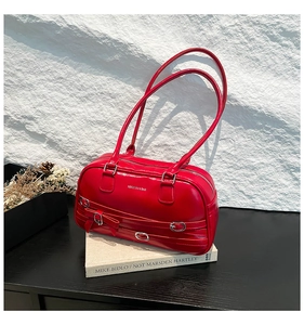 Vue détaillée du sac boston rouge en similicuir avec boucles argentées et nœud