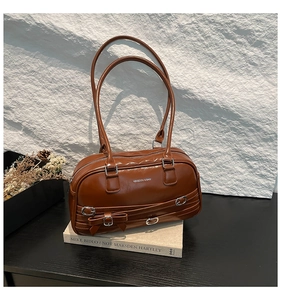 Détail d'un sac Boston marron vintage avec boucle en nœud sur fond de pierre texturée