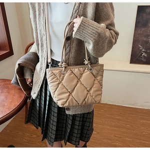 Détail du sac cabas matelassé beige avec surpiqûres en losange et bandoulière réglable