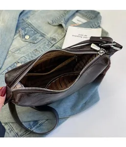 Detailed macro view of internal zipper pocket and DAIKE lining in dark brown bucket bag