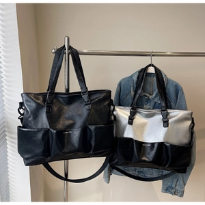 Detail view of large tote bags with multiple pockets in black and silver leather