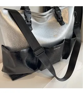 Detail of adjustable nylon strap and quick-release buckle on metallic tote bag