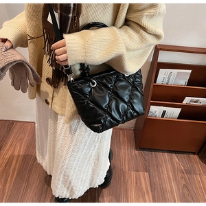 Détail du sac seau noir matelassé en cuir souple plissé avec anneaux en métal argenté