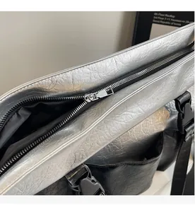 Detail of silver metallic tote bag showing smooth zipper and crinkled texture surface
