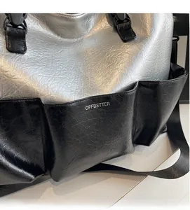 Detail of a large tote bag featuring silver crinkle fabric and black side pockets