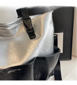 Detail of silver crinkled texture tote bag showing large side pocket and adjustable buckle