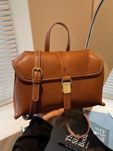 Vintage caramel brown leather crossbody bag with contrast stitching and gold buckle