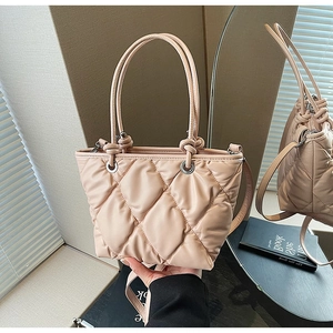 Détail du sac seau en cuir matelassé rose poudré avec poignée nouée et bandoulière