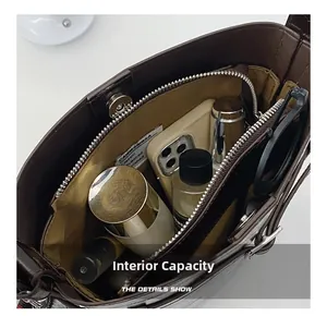 Detailed internal capacity of dark brown bucket bag with yellow lining and zipper pocket