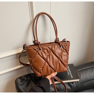 Détail du sac seau matelassé marron avec texture moelleuse et fine bandoulière