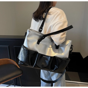 Detailed view of the large silver and black tote bag with multiple front utility pockets