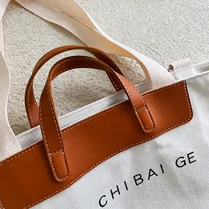 Detail showing high-quality canvas stitching and brown leather handle with brand logo