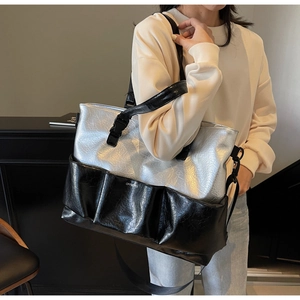 Detail of silver metallic tote bag with pleated pockets and adjustable nylon strap