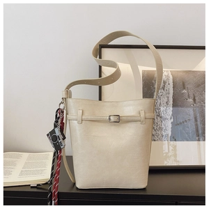 Detailed macro view of cream white bucket bag with vintage texture and stylish charms
