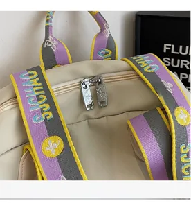 Detail of smooth metal double zippers and colorful woven straps on a nylon backpack