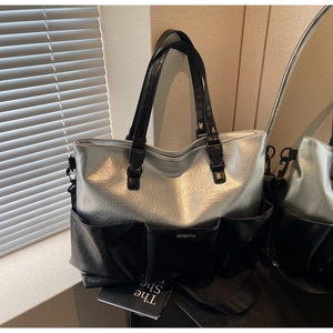 Detail of silver metallic tote bag featuring multi-pocket design and adjustable strap
