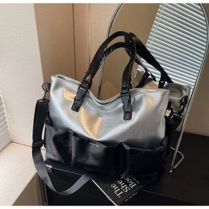 Detail of silver metallic tote bag with multiple pockets and pleated leather texture