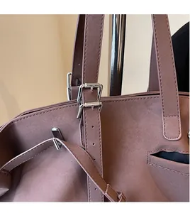 Dettaglio della tracolla regolabile con fibbia argentata su una borsa vintage