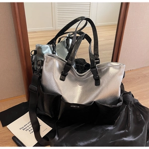 Detail of silver and black tote bag with multiple pockets and detachable strap