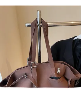Dettaglio della borsa tote in pelle scamosciata marrone con fibbie metalliche argentate