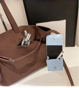 Dettaglio della borsa tote vintage marrone con una piccola borsa blu staccabile extra