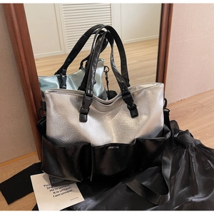 Detail view of large silver and black tote bag with multi-pocket design and adjustable strap