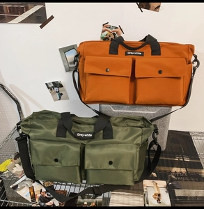 Close-up of army green and orange canvas tote bags with functional large front pockets