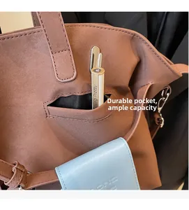 Dettaglio della tasca frontale resistente su borsa tote in pelle scamosciata marrone
