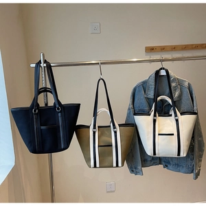 Detailed view of three canvas tote bags in black, khaki, and cream for daily commuting