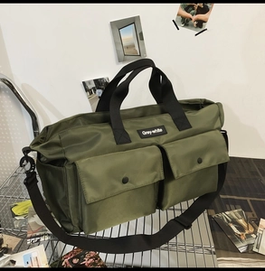 Detail of army green canvas tote bag featuring two front pockets with black snap buttons