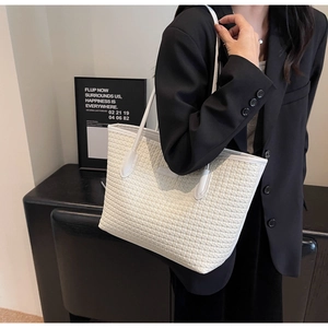 Detail of white woven tote bag texture and slender leather straps on model shoulder