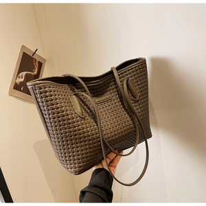 Detail view of large dark brown woven tote bag featuring fine Intrecciato craftsmanship