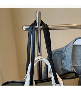 Detail of khaki canvas tote with black leather handles and dual strap design