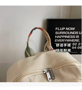 Detail of backpack showing colorful woven handle and durable silver metal zippers