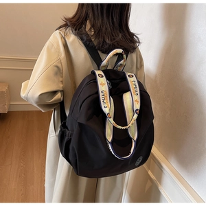 Detail of nylon backpack side pocket and decorative patterned webbing strap on model