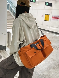 Large orange canvas tote bag for women featuring multiple pockets and crossbody strap
