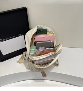 Interior view of off-white backpack showing large capacity for laptop and daily essentials