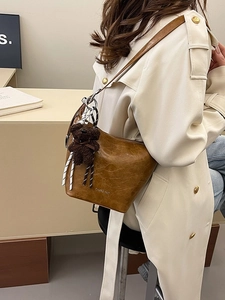 Fashionable brown oil wax leather bucket bag with cute plush bear charm for daily wear