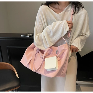 Dettaglio della borsa hobo rosa in finto camoscio indossata da una modella in interno