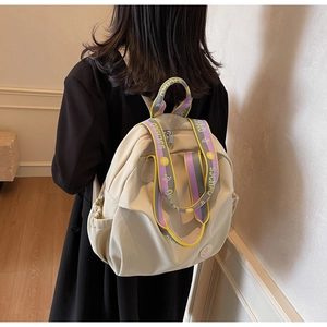 Detail of cream nylon backpack featuring colorful contrast straps and SJCHAO letter printing