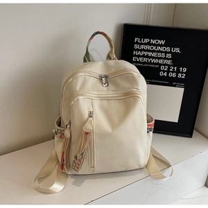 Detailed view of cream nylon backpack with bohemian style colorful patterned straps